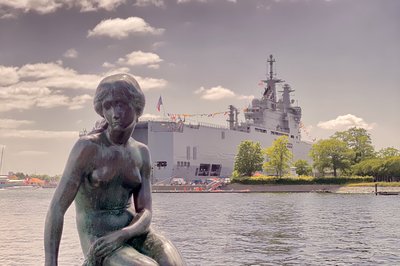 Den obligatoriske havfruen, med et fransk krigsskip i bakgrunnen